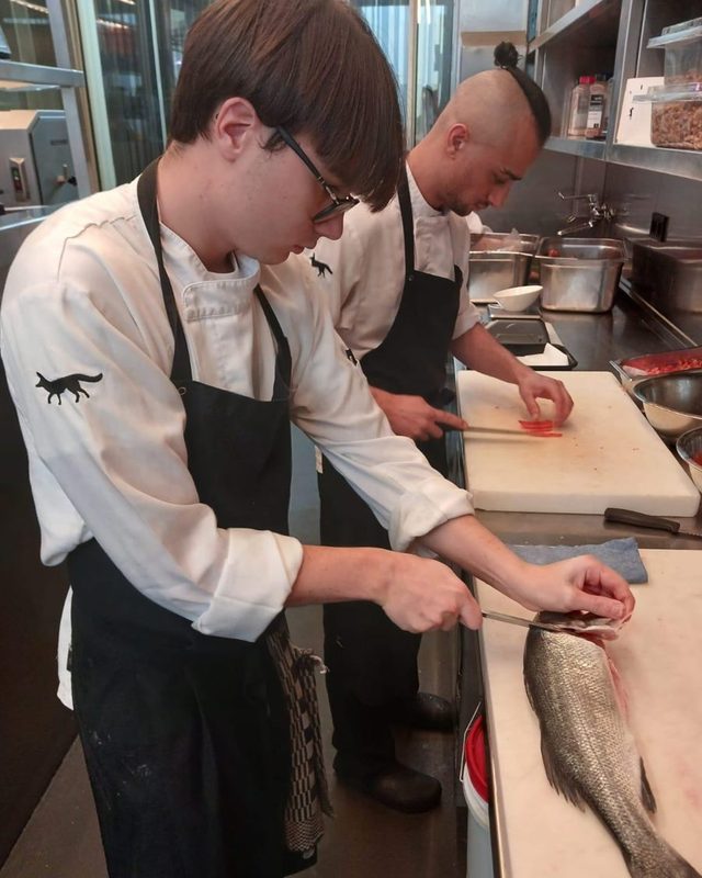 Lorenzo sfiletta un branzino in cucina